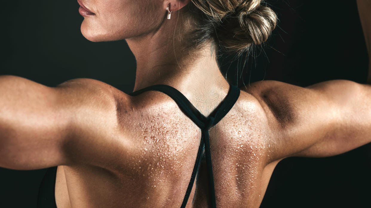  A woman flexing her shoulder muscles. 