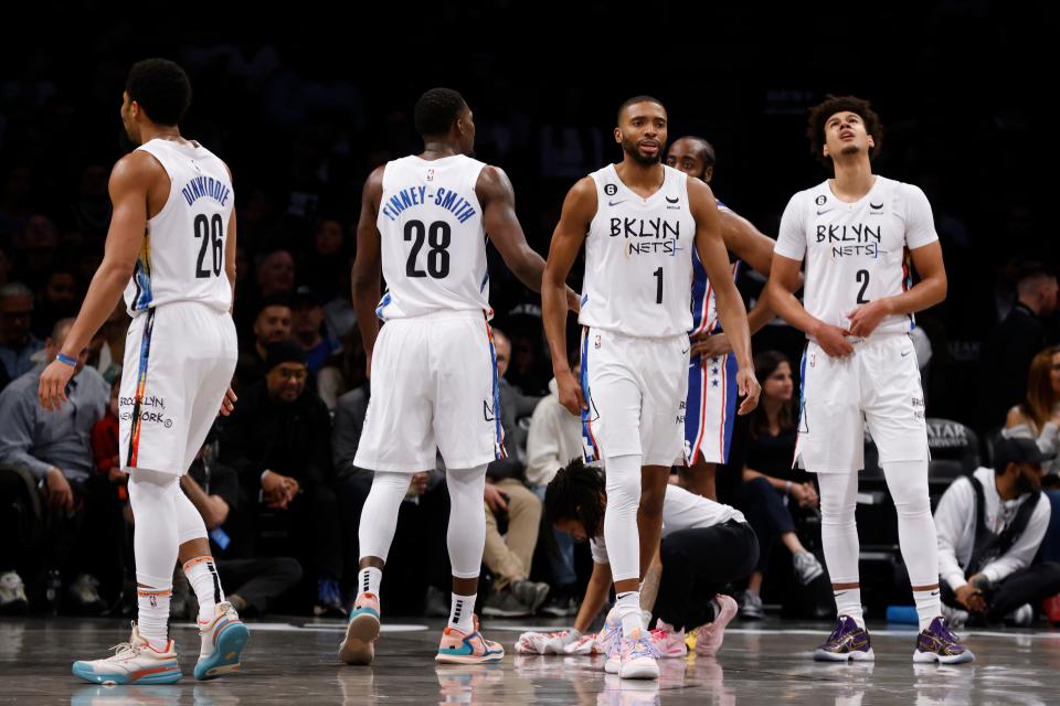 Newly acquired Brooklyn Nets players Spencer Dinwiddie (26), Dorian Finney-Smith (28), Mikal Bridges (1) and Cam Johnson (2) stand on the court during a break in the second quarter action of an NBA basketball game against the Philadelphia 76ers, Saturday, Feb. 11, 2023, in New York. (AP Photo/Jason DeCrow) ORG XMIT: NYJD113