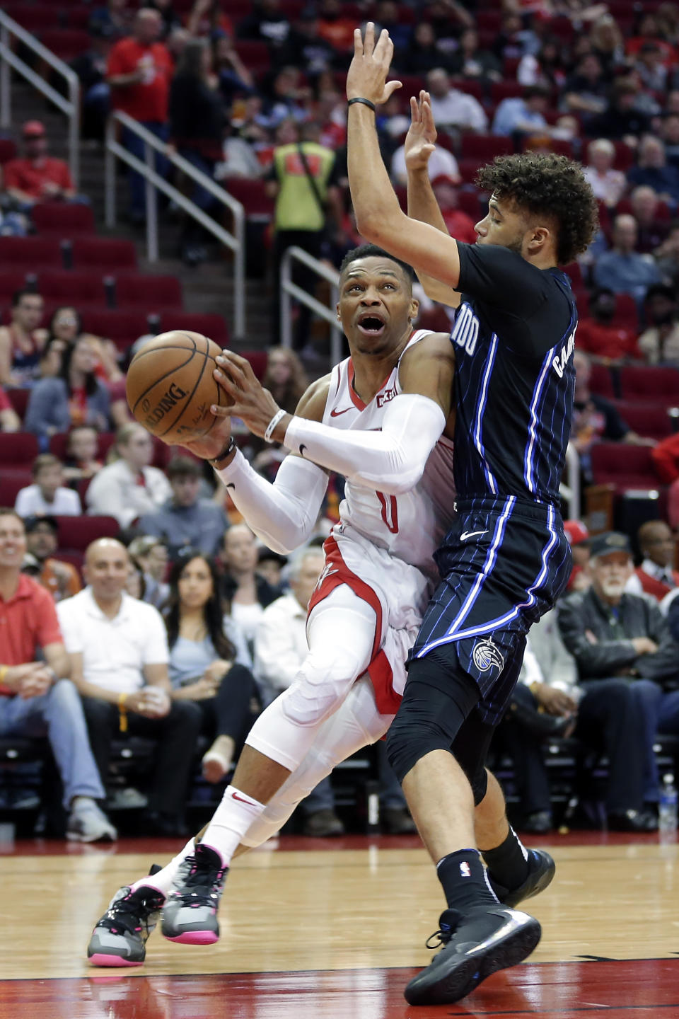 Houston Rockets guard Russell Westbrook, left, drives around Orlando Magic guard Michael Carter-Williams, right, during the first half of an NBA basketball game Sunday, March 8, 2020, in Houston. (AP Photo/Michael Wyke)