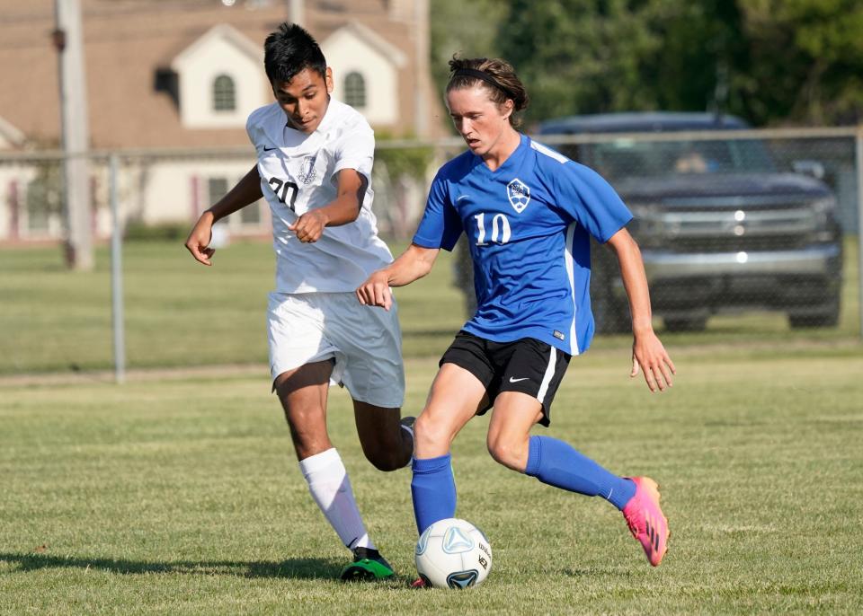 Adrian's Aiden Smith (10) controls the ball while Tecumseh's Santos Millan chases during Wednesday's match at Adrian.