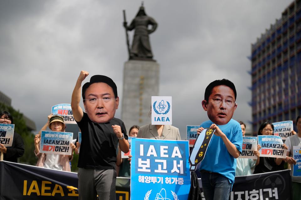 Members of civic groups wearing masks of Japanese Prime Minister Fumio Kishida, right, and South Korean President Yoon Suk Yeol pose during a rally to oppose Japanese government's decision to release treated radioactive water into the sea from the Fukushima nuclear power plant, in Seoul, South Korea, Wednesday, July 5, 2023. The letters read "Report of the IAEA."