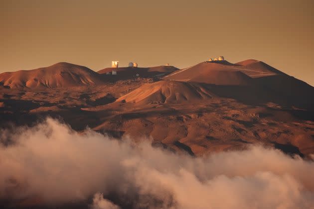 Dramatic evening light shines above the clouds on the observatory and its large astronomical telescopes on the dormant volcano of Mauna Kea in Hawaii. Mauna Kea is considered sacred by native Hawaiians, who want more control over how the mountain is used by scientists. (Photo: Alex Ratson via Getty Images)