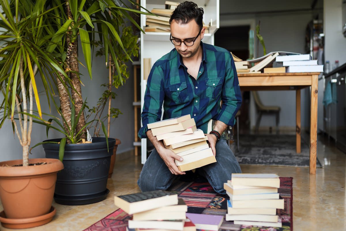 A man goes through his book collection.