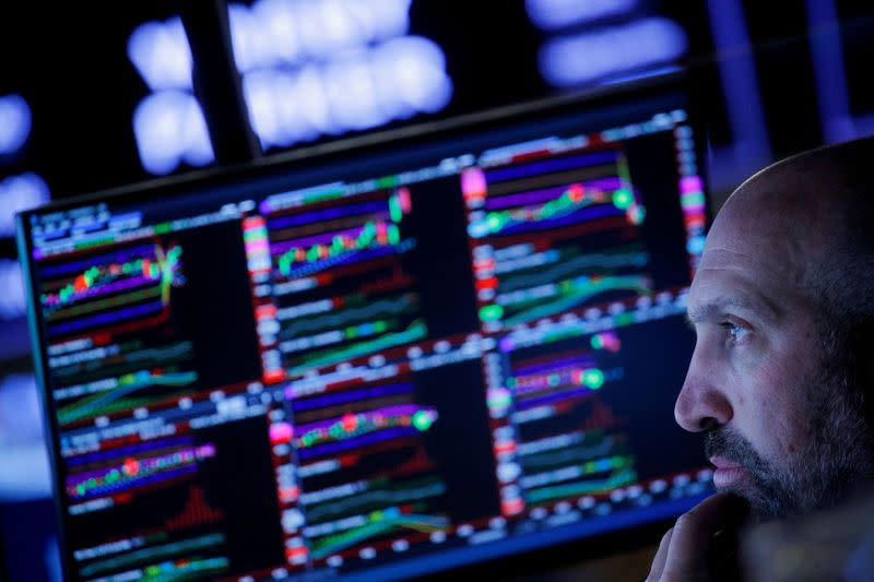 FILE PHOTO: Traders work on the floor of the New York Stock Exchange (NYSE) in New York City