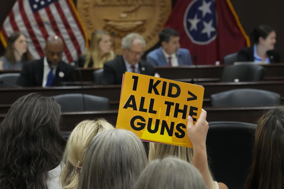 A demonstrator holds a sign for law makers to see during the House Higher Education Subcommittee during a special session of the state legislature on public safety Tuesday, Aug. 22, 2023, in Nashville, Tenn. (AP Photo/George Walker IV)