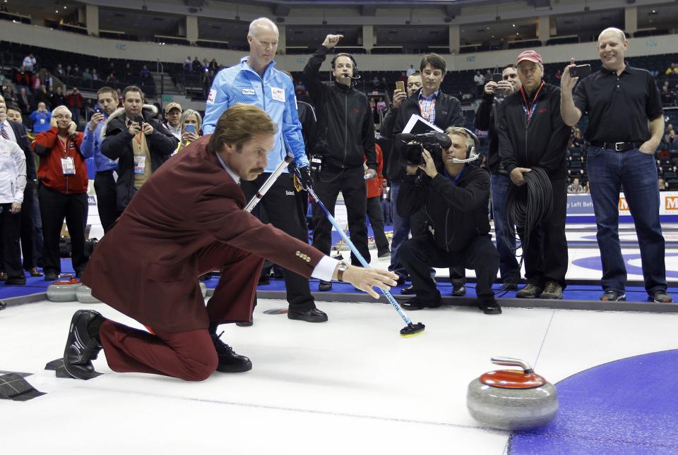 Will Ferrell (L) as Ron Burgundy throws a rock after receiving instructions from Skip Glenn Howard prior to the start of the Roar of the Rings Canadian Olympic Curling Trials in Winnipeg, Manitoba December 1, 2013. REUTERS/Trevor Hagan (CANADA - Tags: SPORT ENTERTAINMENT CURLING)
