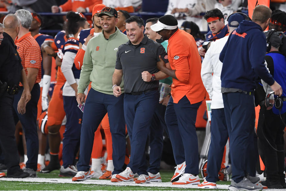 Syracuse interim head coach Nunzio Campanile, center, is congratulated on his first win in an NCAA college football game against Wake Forest in Syracuse, N.Y., Saturday, Nov. 25, 2023. Campanile took over for Dino Babers who was fired earlier in the week. (AP Photo/Adrian Kraus)