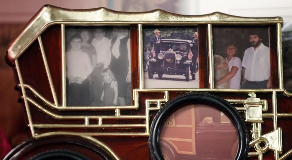 Old photographs of family memories with the Caines Flowers 1931 Chevrolet Woody are framed on the shelf at the Barberton shop.