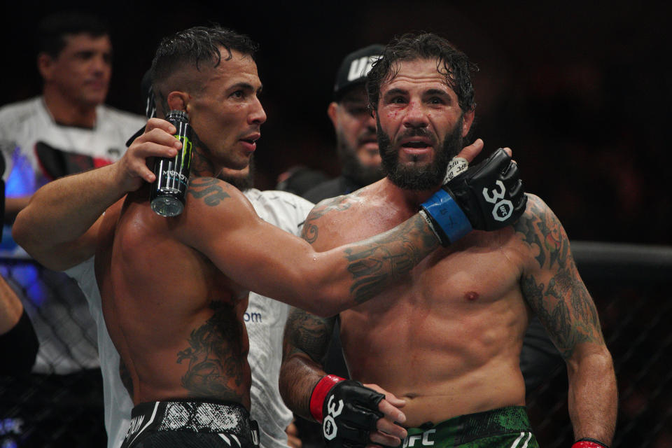 Dec 2, 2023; Austin, Texas, USA; Clay Guida (red gloves) hugs Joaquim Silva (blue gloves) after their fight during UFC Fight Night at Moody Center. Mandatory Credit: Dustin Safranek-USA TODAY Sports