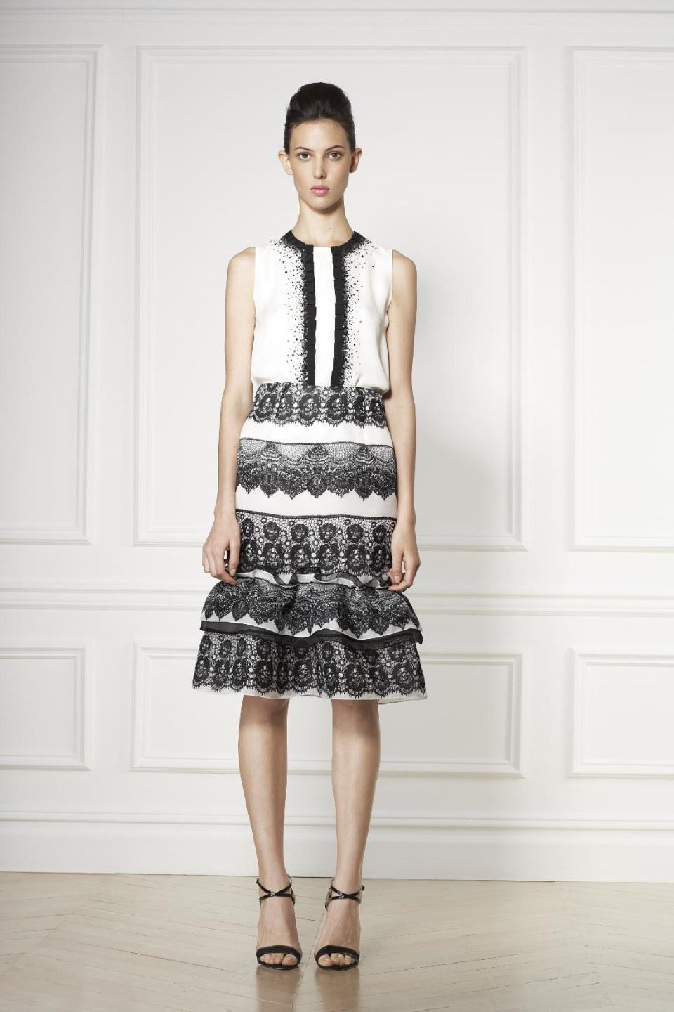 This undated image released by Carolina Herrera, a model wears a white tiered cocktail dress trimmed with black lace from the Carolina Herrera 2013 resort collection. (AP Photo/Carolina Herrera)