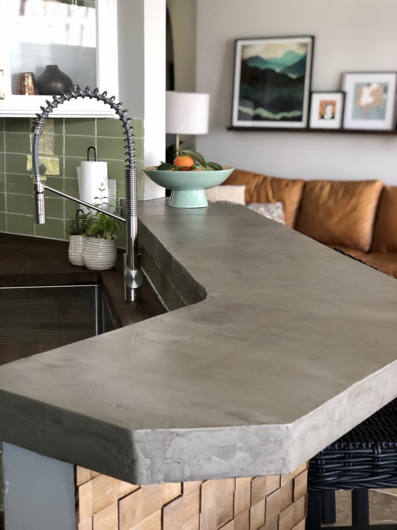 Island countertop with feathered concrete finish in gray color.