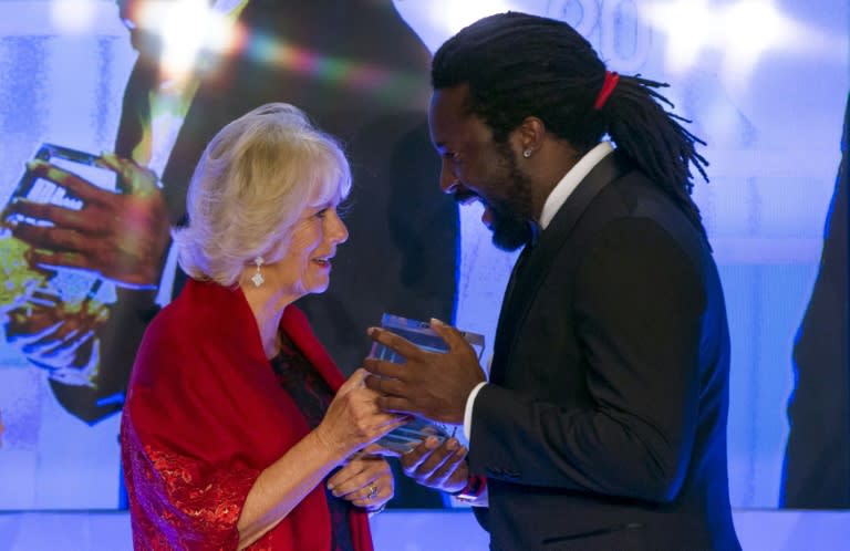 Britain's Camilla, Duchess of Cornwall (L), presents Jamaican author Marlon James with the 2015 Man Booker Prize for Fiction award at the Guildhall in central London on October 13, 2015