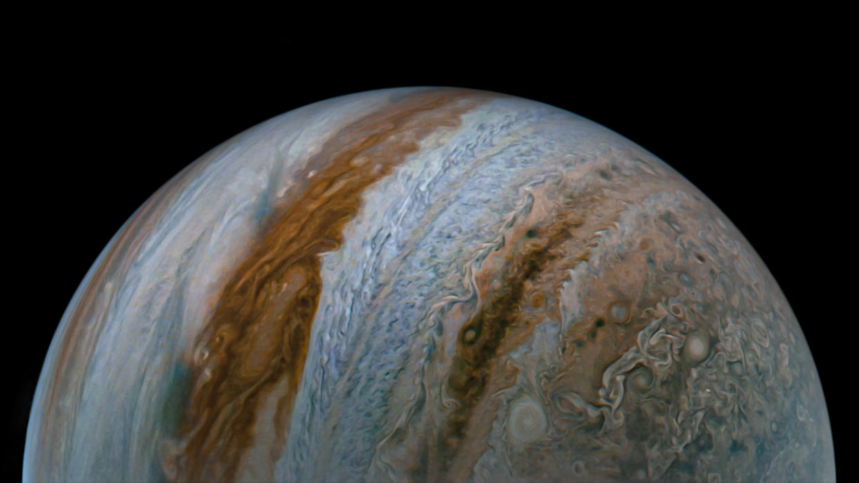  Half of Jupiter is seen rising like an orb from image bottom from the Juno spacecraft Sep. 7, with intricate stripes of different colored gasses striping the atmosphere. 