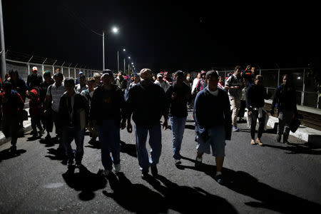 People belonging to a caravan of migrants from Honduras en route to the United States, walk at the border crossing to Mexico, in Hidalgo, Mexico, January 18, 2019. REUTERS/Jose Cabezas