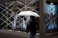 A woman walks past the windows of a boutique store that have been taped-up in preparation for Typhoon Usagi at Tsim Sha Tsui shopping district in Hong Kong September 22, 2013. Hong Kong was bracing on Sunday for this year's most powerful typhoon, with government meteorologists warning of severe flooding created by a double whammy of powerful winds and exceptionally high tides.REUTERS/Tyrone Siu (CHINA - Tags: BUSINESS ENVIRONMENT DISASTER)