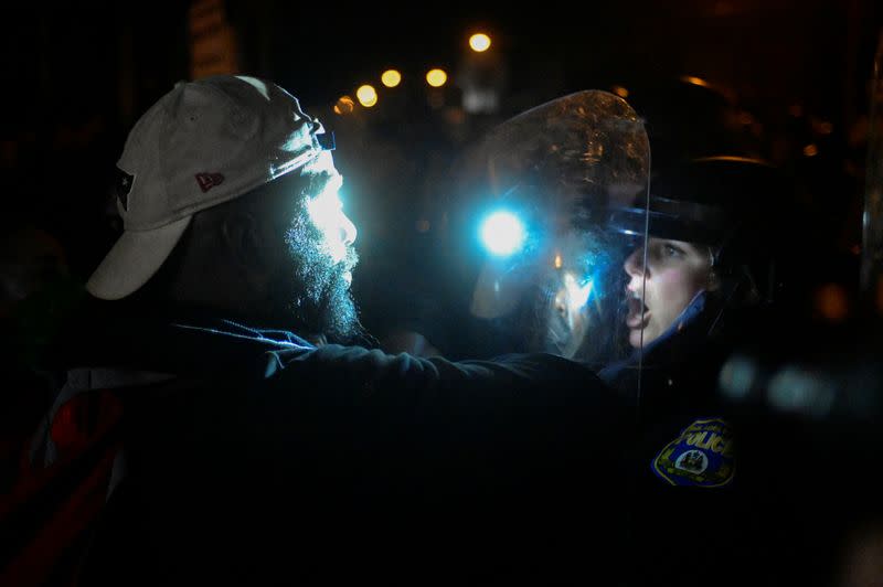 A demonstrator confronts a police officer outside the 18th District Police station during a rally after the death of Walter Wallace Jr., a Black man who was shot by police in Philadelphia