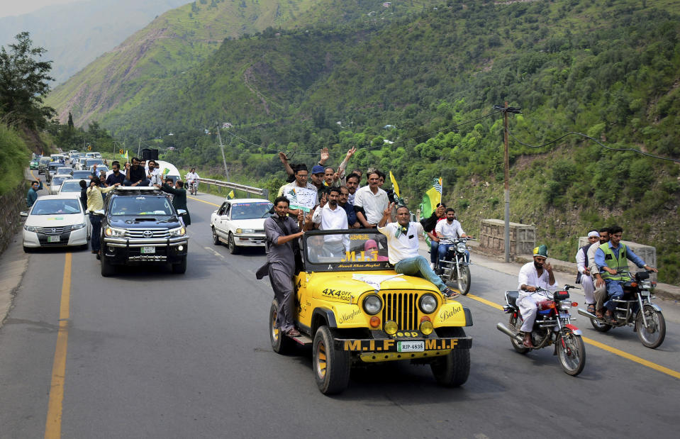 Journalists make victory signs while take part in a rally marching towards the Line of Control, which divides the Himalayan region, in Chinari, a small of Pakistani control's Kashmir, Saturday, Aug. 24, 2019. Pakistani police have stopped hundreds of journalists from symbolically trying to cross the highly militarized border into Indian-controlled Kashmir. (AP Photo/M.D. Mughal)