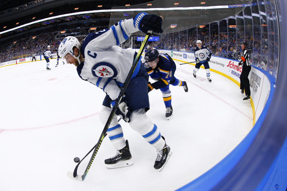 Winnipeg Jets winger Blake Wheeler (26) fights St. Louis Blues center Oskar Sundqvist (70), of Sweden, for control of the puck during the third period of an NHL hockey game Sunday, Dec. 29, 2019, in St. Louis. (AP Photo/Dilip Vishwanat)