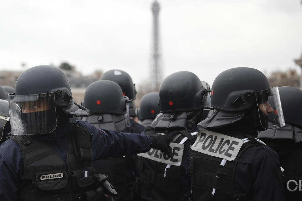 Riot Police take position during clashes with yellow vest protesters around the Arc of Triomphe, in Paris, France, Saturday, Jan. 12, 2019. Authorities deployed 80,000 security forces nationwide for a ninth straight weekend of anti-government protests. (AP Photo/Kamil Zihnioglu)