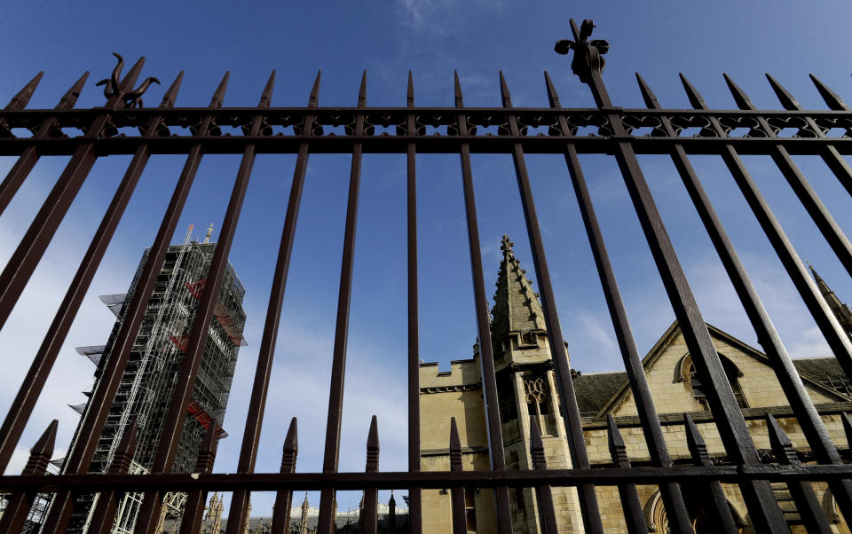 Britain's Parliament buildings through the outside railings in London, Friday, Oct. 18, 2019. Britain's Parliament is set to vote Saturday on Prime Minister Boris Johnson's new deal with the European Union, a decisive moment in the prolonged bid to end the Brexit stalemate. Various scenarios may be put in motion by the vote.(AP Photo/Kirsty Wigglesworth)