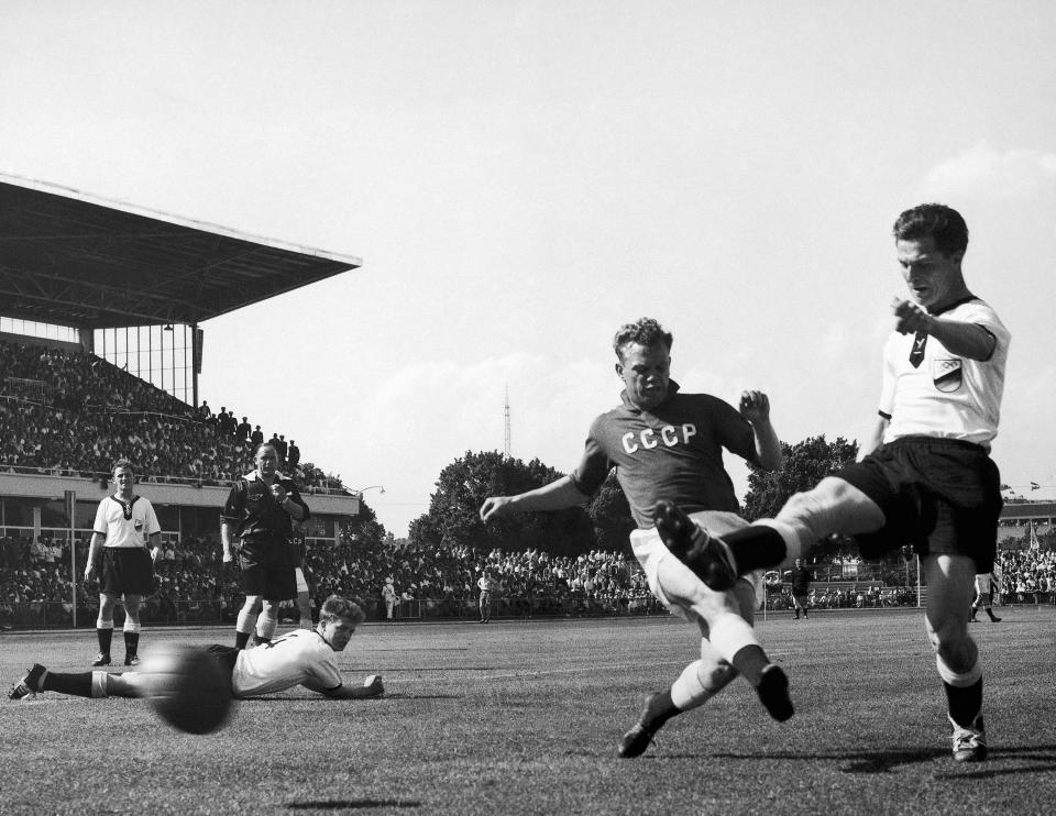 FILE - In this Nov. 24, 1956, file photo, German inside right Rolf K. Geiger, right, gets the ball past a Soviet defender during the Germany vs Russia Olympic Association Football match on the Olympic Park football field in Melbourne, Australia on. Russia won 2-1. (AP Photo/Stuart Heydinger, File)