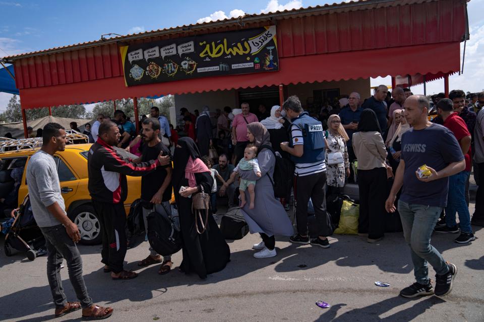 Palestinians wait to cross into Egypt at the Rafah border crossing in the southern Gaza Strip on Oct. 16, 2023. A day later, an Israeli airstrike hit the Gaza side.