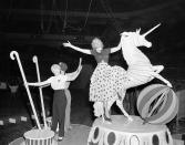 <p>Getting ready for the unfolding of the symbolic “big top” for the 1953 season, circus folk from Ringling Bros. and Barnum and Bailey Circus limber up at Madison Square Garden in New York, March 31, 1953, where the show makes its debut on April 1. Ann Mace, right, former Diamond Horseshoe showgirl, in street clothes, rides on the featured float, “The Spirit of Candy Land,” from the “Spectacle” number. (AP Photo/Ed Ford) </p>