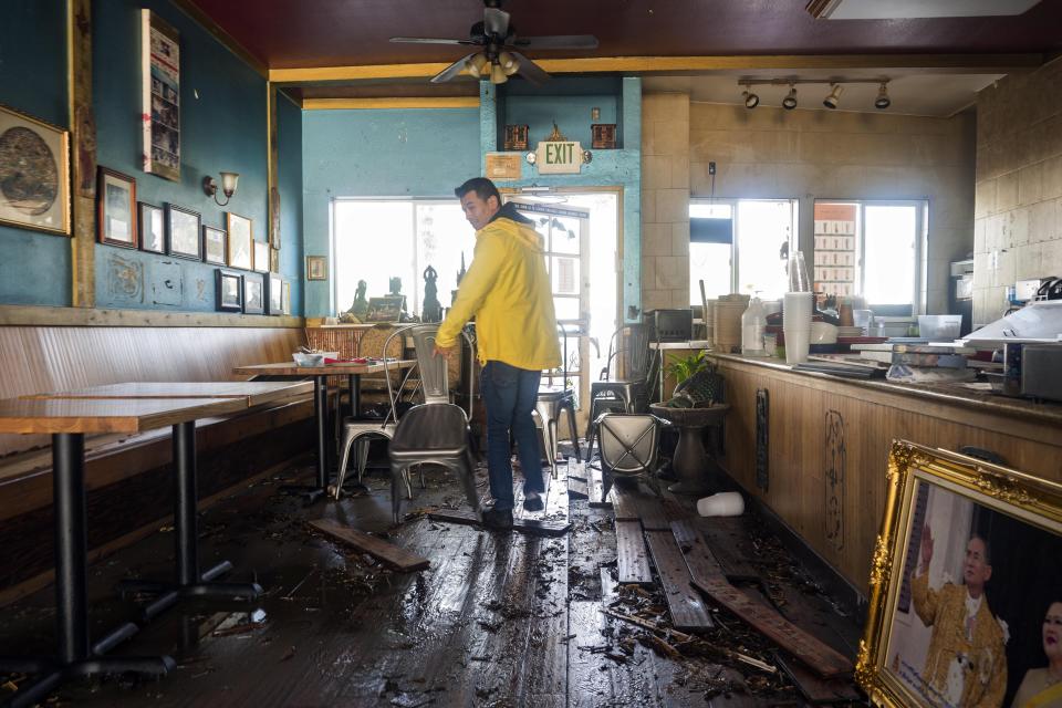 Dominic King, owner of My Thai Beach, surveys storm damage that destroyed his restaurant in Captiola, Calif., Thursday, Jan. 5, 2023. Damaging hurricane-force winds, surging surf and heavy rains from a powerful “atmospheric river” pounded California on Thursday, knocking out power to tens of thousands, causing flooding, and contributing to the deaths of at least two people, including a child whose home was hit by a falling tree. (AP Photo/Nic Coury)