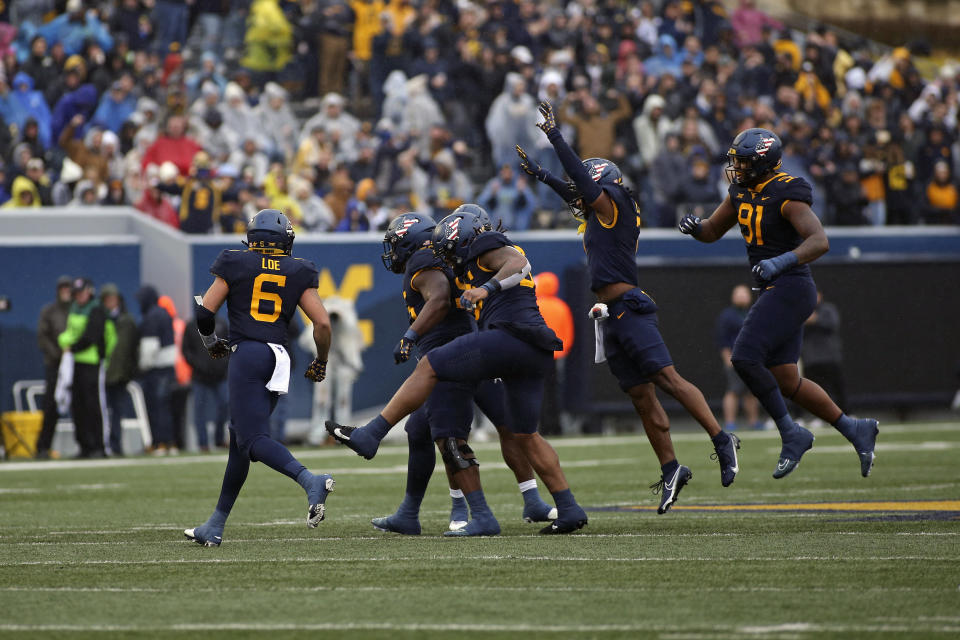 West Virginia players celebrate during the first half of an NCAA college football game against Oklahoma in Morgantown, W.Va., Saturday, Nov. 12, 2022. (AP Photo/Kathleen Batten)