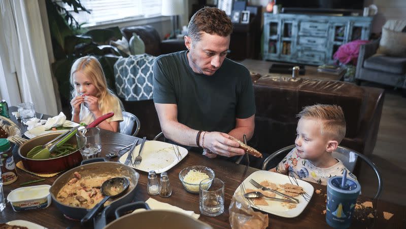 Tyson Wyatt of Castle Rock, Colorado, tries unsuccessfully to convince his son TJ, 5, to try some buttered bread at the dinner table as his daughter Charlotte, 8, eats in the background, on Friday, March, 31, 2023. TJ is an extremely picky eater and has been attending food therapy sessions for his eating, which is limited to mostly one brand of granola bar, certain crackers, string cheese and chocolate milk.