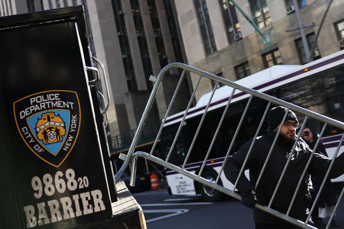 NYPD officers drop off metal barricades in front of the Manhattan Criminal Court in New York City on Monday amid reports Donald Trump may be indicted (Getty)