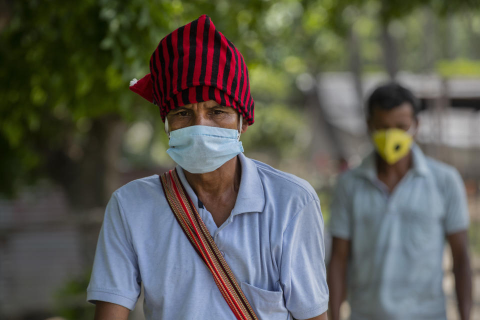 Indian villagers currently residing at a containment zone arrive to test for COVID-19 in Burha Mayong village, Morigaon district of Assam, India, Saturday, May 22, 2021. (AP Photo/Anupam Nath)