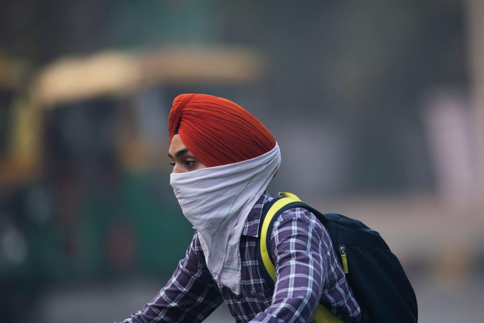 A motorist covering up his face rides along a street in smoggy conditions in New Delhi on Nov. 1, 2019. (Photo: Jewel Samad/AFP via Getty Images)