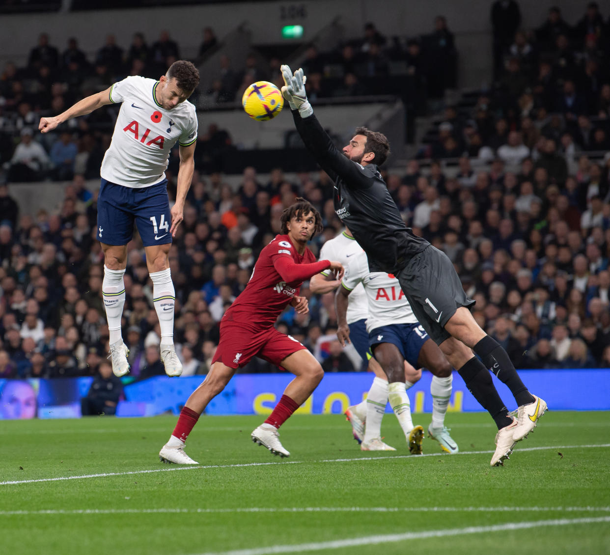 Liverpool goalkeeper Alisson Becker (right) tries to punch the ball away from Tottenham Hotspur's Ivan Perisic (left) during their English Premier League match