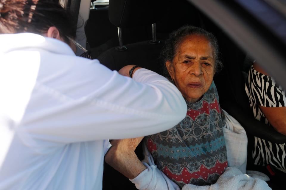 Nurse Practitioner Samantha Soto gives a flu vaccination to Dima Radilla, age 92, during a drive through clinic at the St. Joseph's/Candler Good Samaritan Clinic in Garden City.