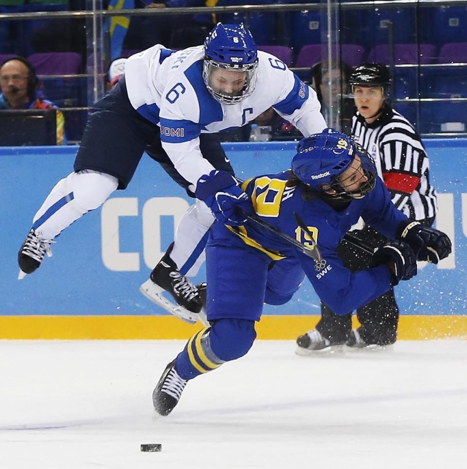 Jenni Hiirikoski of Finland (6) and Maria Lindh of Sweden collide during the 2014 Winter Olympics women's quarterfinal ice hockey game at Shayba Arena, Saturday, Feb. 15, 2014, in Sochi, Russia. 