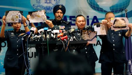 Commissioner Amar Singh, Malaysia's Federal Commercial Crime Investigation Department (CCID) director, and other police officers display photos of items from a raid during a news conference in Kuala Lumpur, Malaysia June 27, 2018. REUTERS/Lai Seng Sin