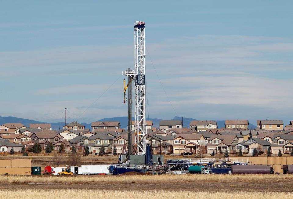 This photo taken on Thursday, Jan. 19, 2012, near Frederick, Colo., shows an oil well being drilled on a property across from a subdivision.