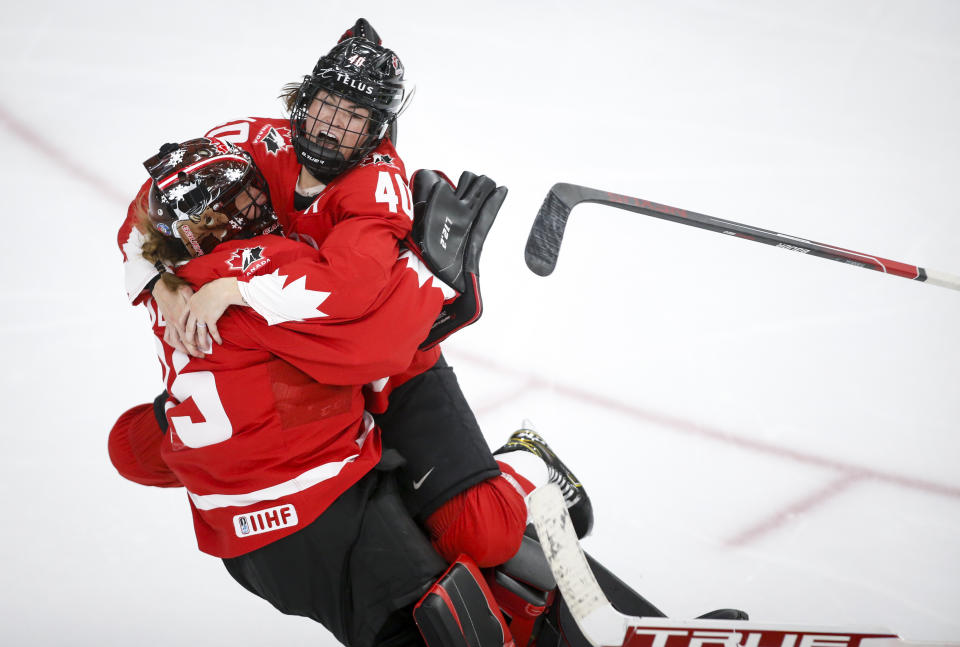 Canada goalie Ann-Renee Desbiens, left, and teammate Blayre Turnbull celebrate the team's overtime win against the United States in the IIHF hockey women's world championships title game in Calgary, Alberta, Tuesday, Aug. 31, 2021. (Jeff McIntosh/The Canadian Press via AP)