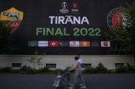 People walk past a Europa Conference League poster, in downtown of Tirana, Albania, Tuesday, May 24, 2022. Feyenoord will play Roma Wednesday in the Europa Conference League Final. (AP Photo/Antonio Calanni)