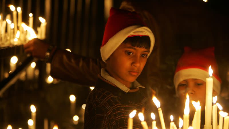 Children light candles at the Sacred Heart Church on Christmas Eve, in New Delhi, India, Saturday, Dec. 24, 2005.