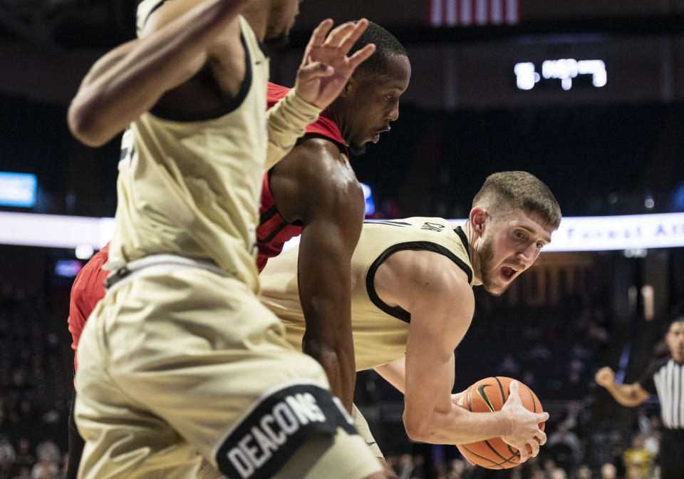 Wake Forest forward Andrew Carr (11) moves around the defense of Rutgers' forward Aundre Hyatt (5) during the first half of an NCAA college basketball game on Wednesday, Dec. 6, 2023, at Joel Coliseum in Winston-Salem, N.C. (Allison Lee Isley/The Winston-Salem Journal via AP)