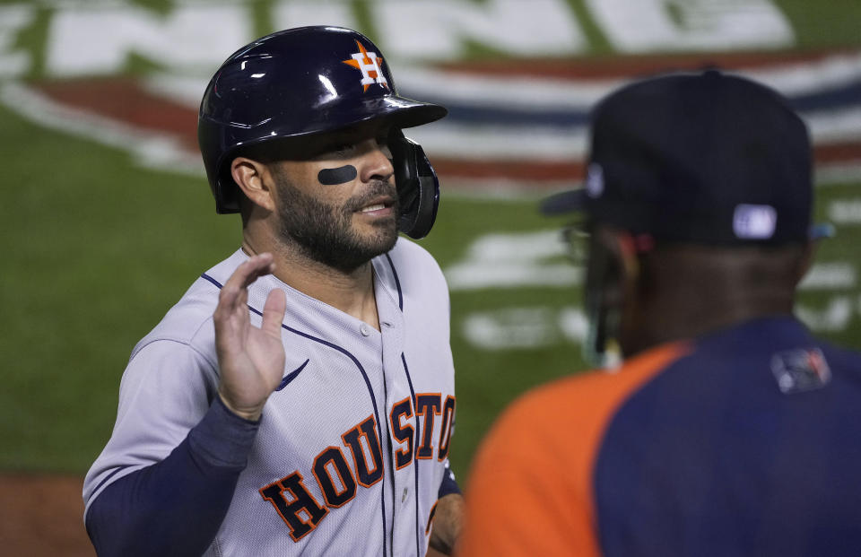 Houston Astros' Jose Altuve (27) is greeted by manager Dusty Baker Jr. after scoring against the Oakland Athletics during the fourth inning of an opening-day baseball game Oakland, Calif., Thursday, April 1, 2021. (AP Photo/Tony Avelar)