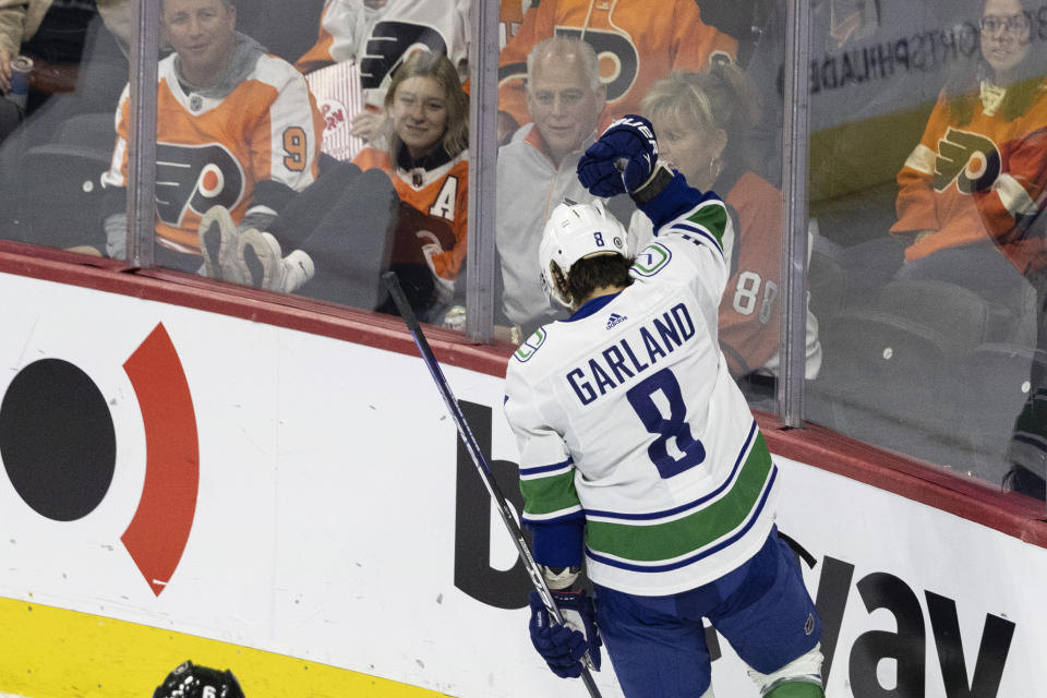 Vancouver Canucks right wing Conor Garland (8) celebrates after his goal as he skates past Philadelphia Flyers fans during the first period of an NHL hockey game, Saturday, Oct. 15, 2022, in Philadelphia. (AP Photo/Laurence Kesterson)