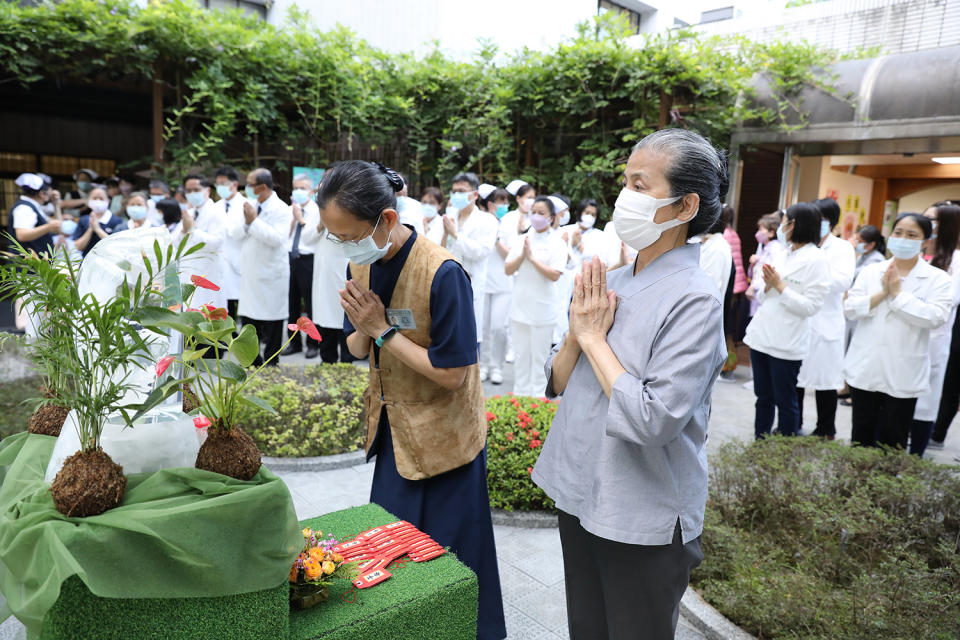 常住志工顏靜曦師姊(右)與醫療志工倆倆一起虔誠合十祈禱。(陳安俞攝)