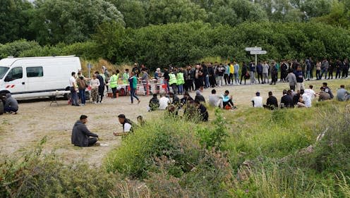 <span class="caption">Refugees in line for food outside a 'wild camp' in Loon Plage in 2023.</span> <span class="attribution"><span class="source">Frédérique de Bels</span></span>