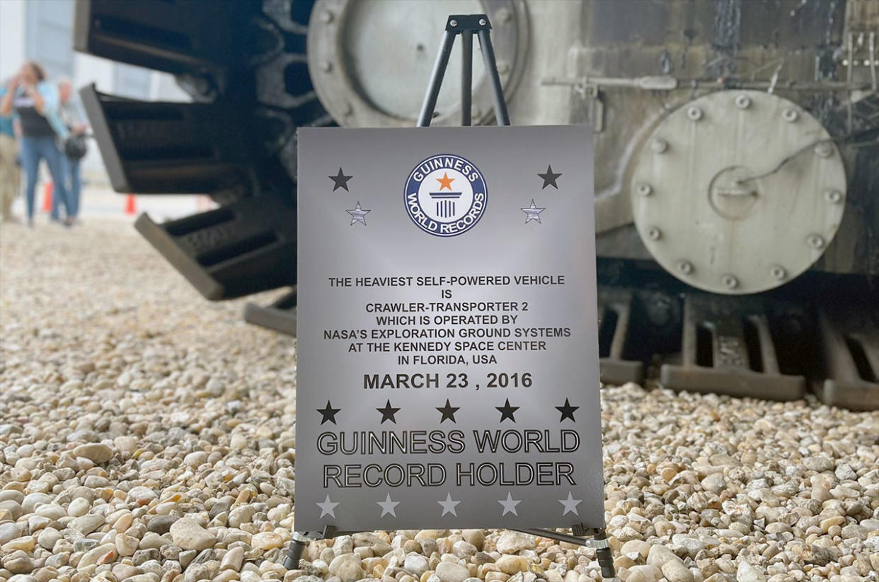  A sign positioned near one of the giant tracks of NASA's Crawler-Transporter 2 identifies the Artemis-upgraded, Apollo-era vehicle as a Guinness World Record holder. 