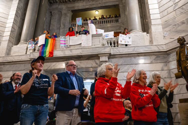 Supporters of SB 150 clap during a press conference in support of SB 150 while those opposed to the bill show signs above on March 29, 2023 at the Kentucky State Capitol in Frankfort, Kentucky. SB 150, which was proposed by State Senator Max Wise (R-KY), is criticized by many as a “Don’t Say Gay” bill and was vetoed by Kentucky Governor Andy Beshear during the General Assembly. Lawmakers did override the governor’s veto. (Jon Cherry/Getty Images)