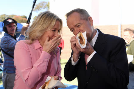 Australian Opposition Leader Bill Shorten and his wife Chloe eat "democracy sausage" sandwiches after casting their votes at Moonee Ponds West Primary school in Melbourne, Saturday, May 18, 2019. AAP Image/Lukas Coch/via REUTERS