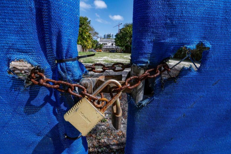 Un candado y una valla de eslabones de cadena saludan a los transeúntes en el 3159 de Virginia St. en Coconut Grove, Florida, el jueves 9 de febrero de 2023. La propiedad es de Doug Cox/Drive Development.